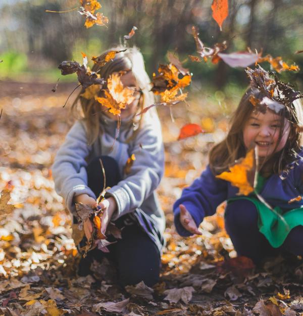 Kinderen spelen met vallende bladeren
